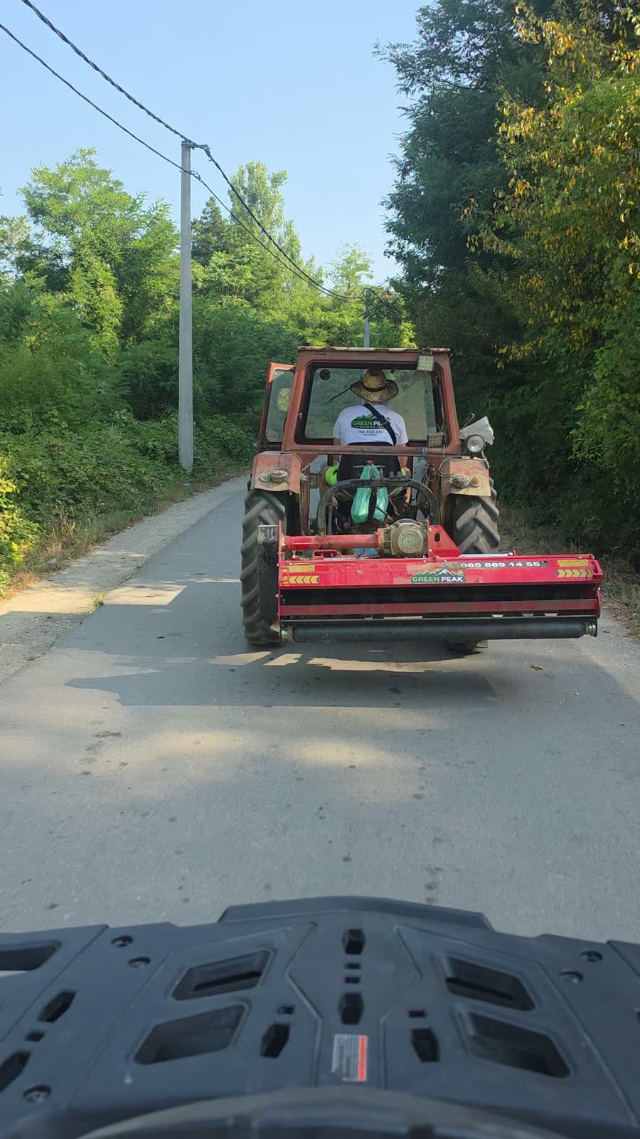 Traktor sa malčerom i robot na prikolici na putu do parcele